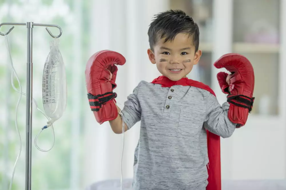 little boy wearing boxing gloves with iv